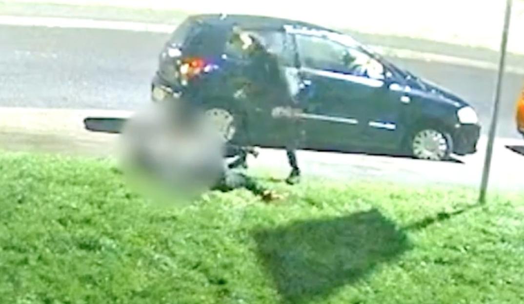 A blurred image of a person assaulting another person with a machete.