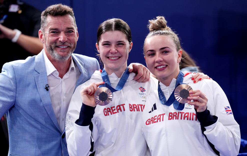 Fred Sirieix with his daughter and her diving partner, both holding bronze medals.