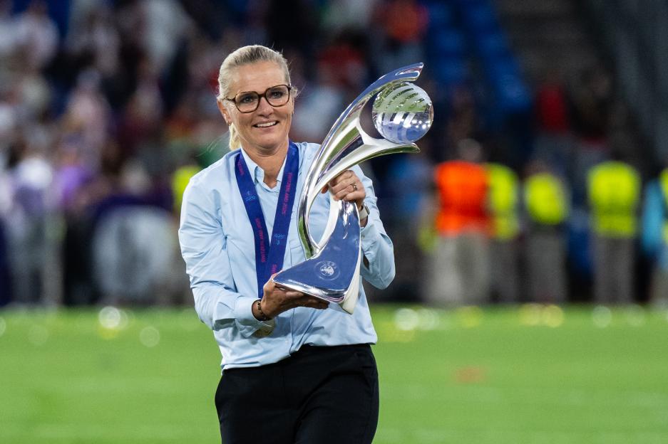 Sarina Wiegman, England's head coach, holding the UEFA Women's EURO 2025 trophy.