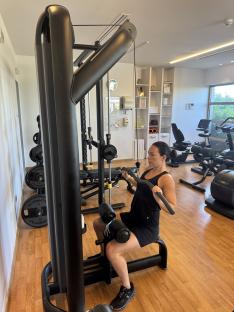 Woman using a lat pulldown machine in a gym.