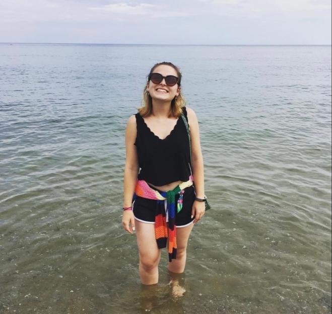 Woman standing in shallow water smiling.