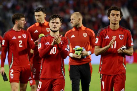 Wales soccer players applaud fans.