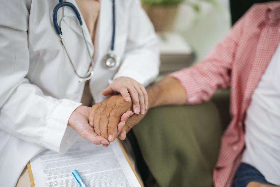 Doctor holding elderly patient's hands.