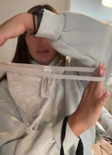 Woman holding up Primark underwear, warning about quality.