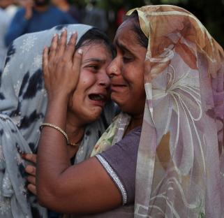 Two women embrace and weep.