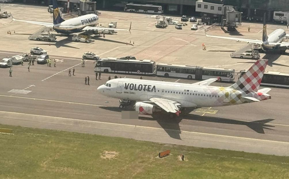 Milan airport tarmac with two planes and emergency personnel.