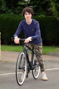 Teenage boy with bicycle.