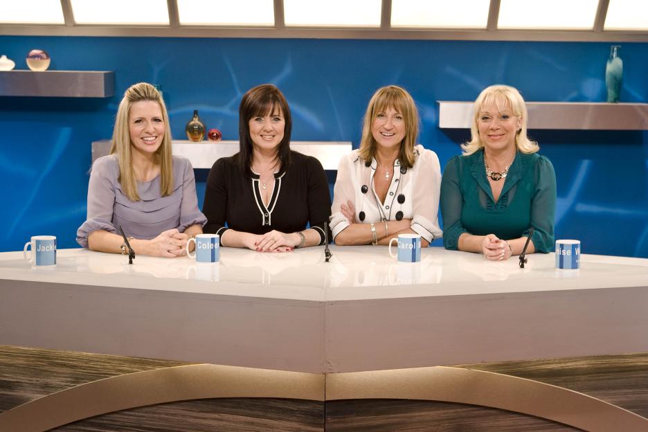 Four women sitting at a table on a television program.
