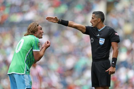 Soccer referee signaling to a player.