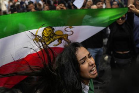 a woman holding a green white and red flag with a lion on it