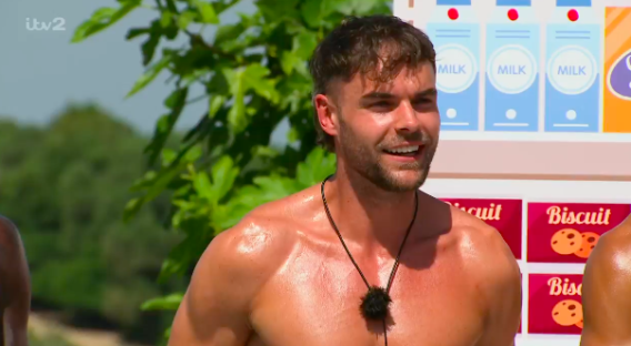 Shirtless man smiling.