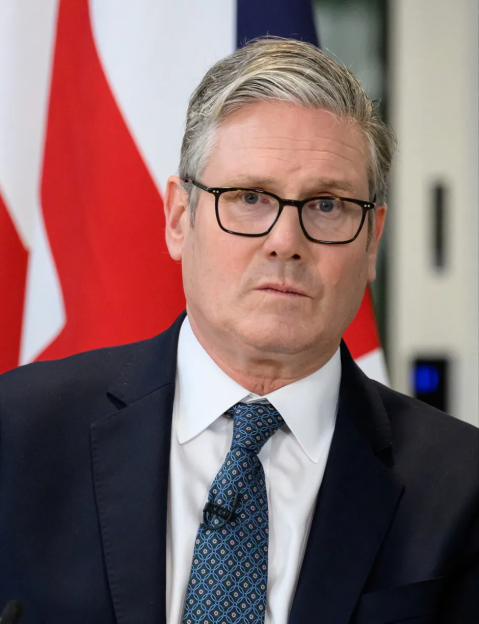Portrait of a man in a suit and glasses.