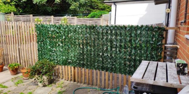 Artificial ivy privacy screen attached to a wooden fence.