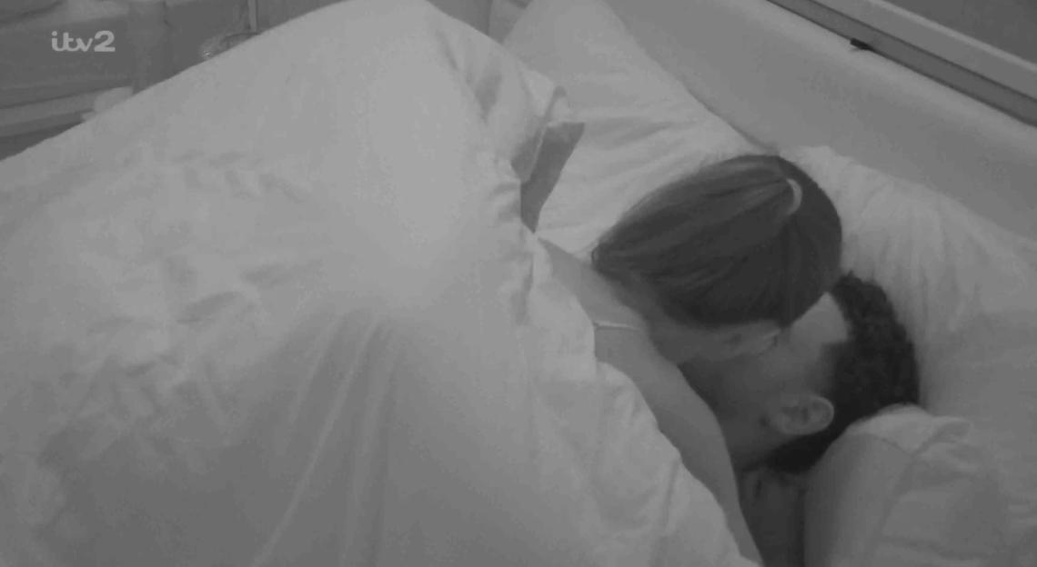 Black and white still image of a couple in bed.