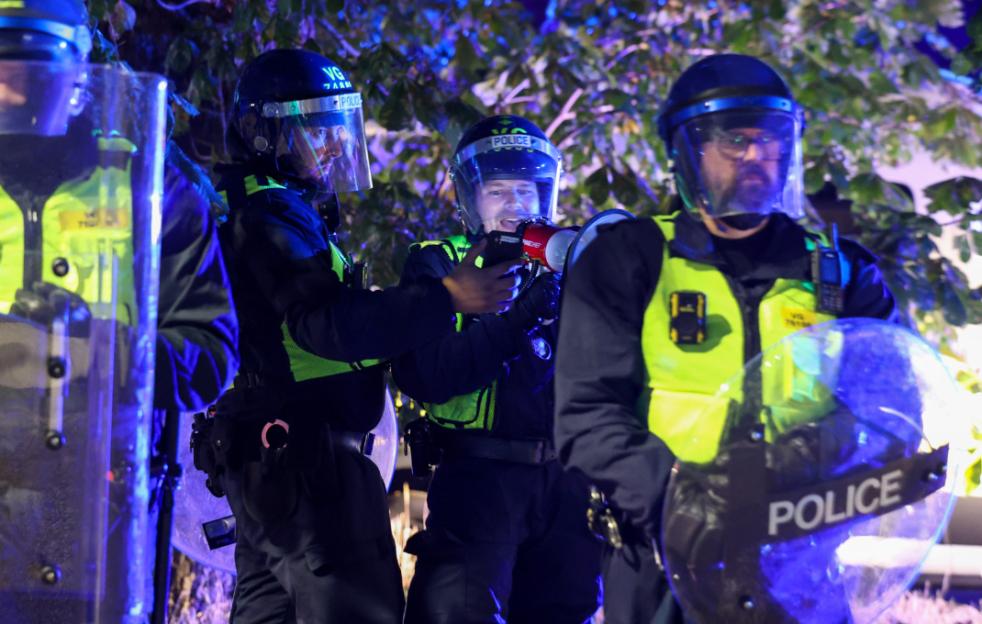 Police officers in riot gear at a protest.