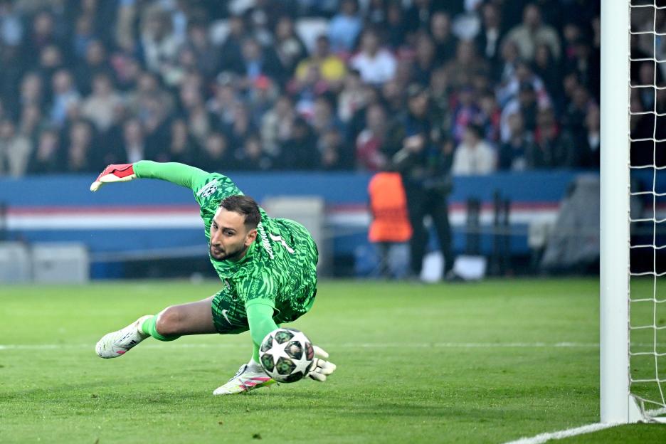 Gianluigi Donnarumma making a save during a soccer game.