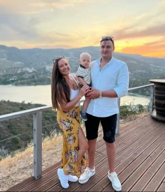 Family photo at sunset overlooking a lake and mountains.