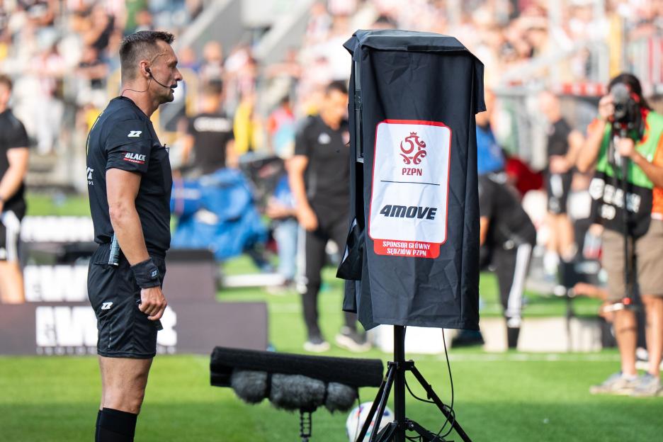 Referee reviewing a video replay on a monitor.