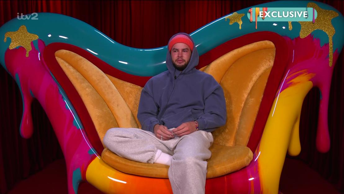 Chris Hughes crying on a brightly colored chair.