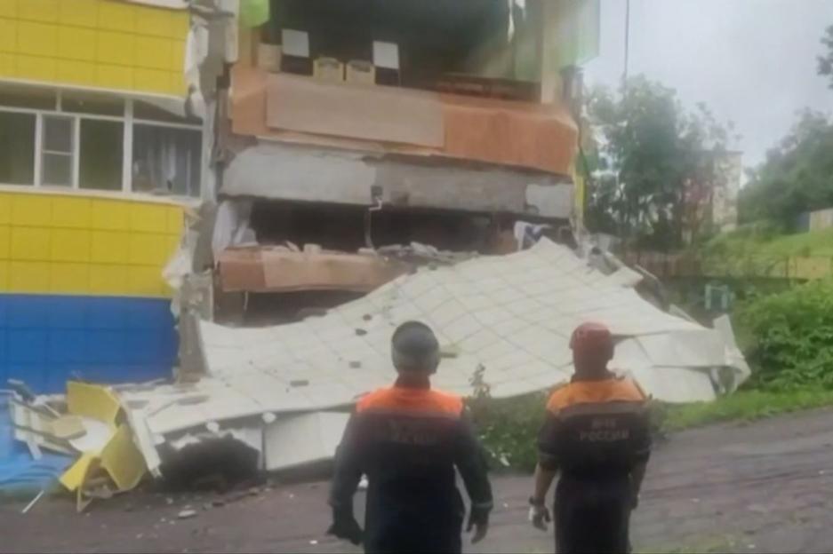 Building facade collapse with emergency personnel on site.