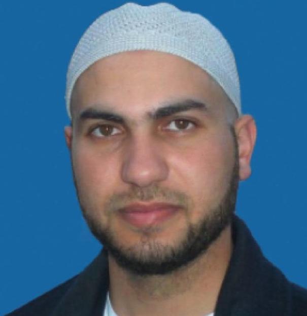 Headshot of a man wearing a kufi.