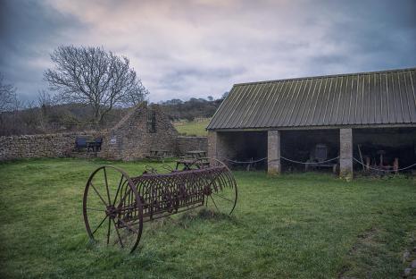 Old farm equipment in a field.