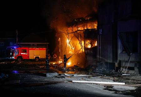 Firefighters battling a large fire at a market at night.