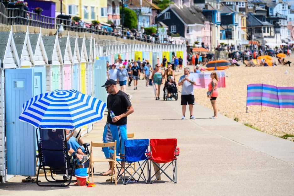 People enjoying hot weather at a beach in Lyme Regis, Dorset.