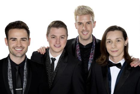 Four men in suits smiling for a photo.