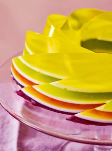 Layered rainbow jelly on a glass plate.