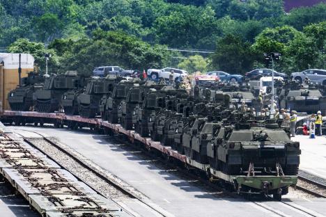 Military vehicles on a train car.