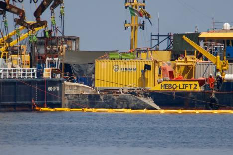 Floating crane ships recovering a sunken yacht.
