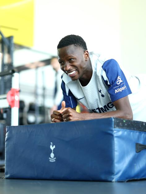 Pape Matar Sarr of Tottenham Hotspur doing a plank exercise.