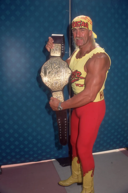 Hulk Hogan holding a championship belt.