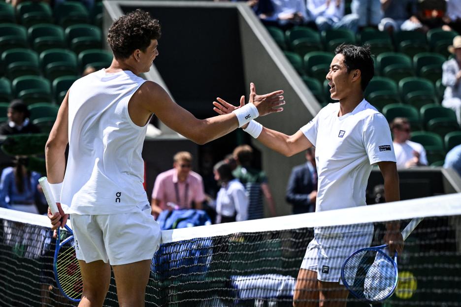 Two tennis players shaking hands at the net.