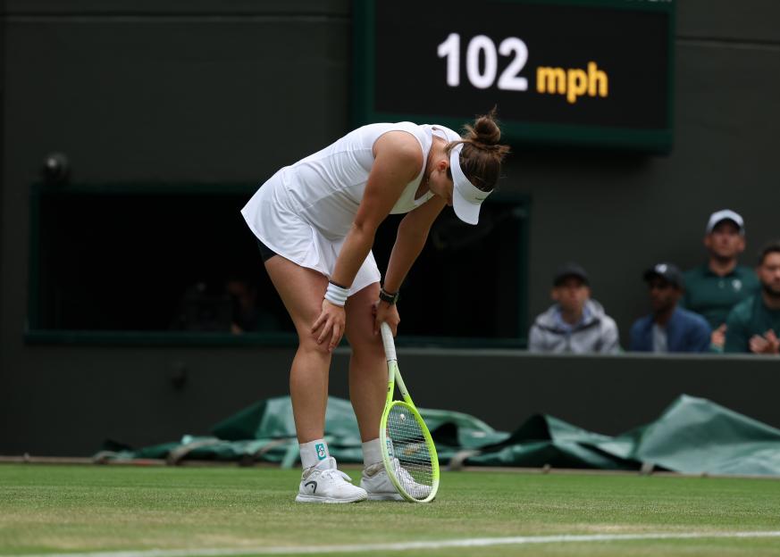 Tennis player Barbora Krejcikova bends over in pain during a match at Wimbledon.