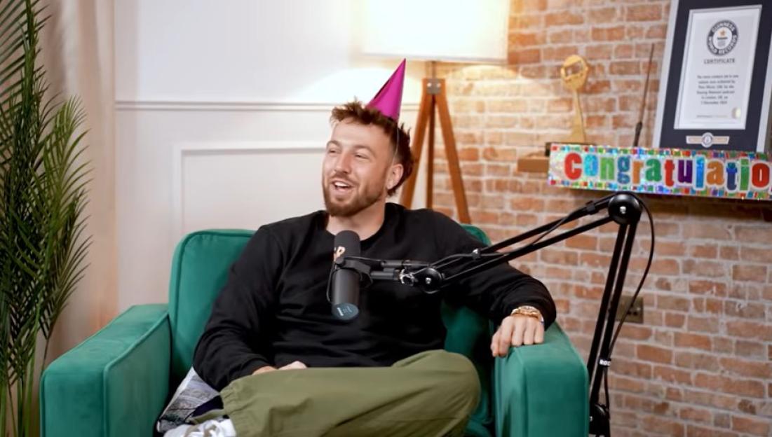 Sam Thompson wearing a party hat during a podcast interview.