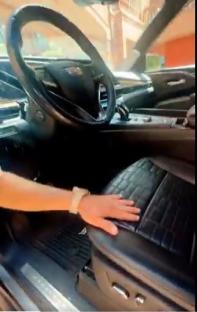 Hand resting on a car's leather seat.