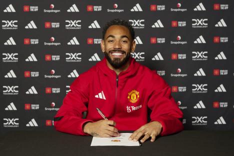 Matheus Cunha signing his Manchester United contract.
