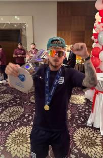 Harvey Elliot holding a trophy and a gold medal.