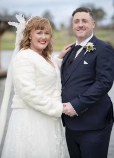 A bride and groom posing for a wedding photo.