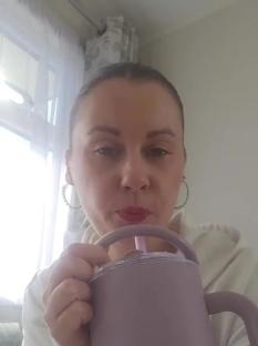 Person drinking from a purple mug with a straw.