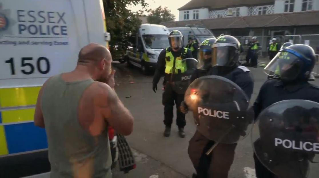 Riot police confronting a man.