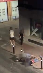 A man being choked to the ground by another man while bystanders watch.