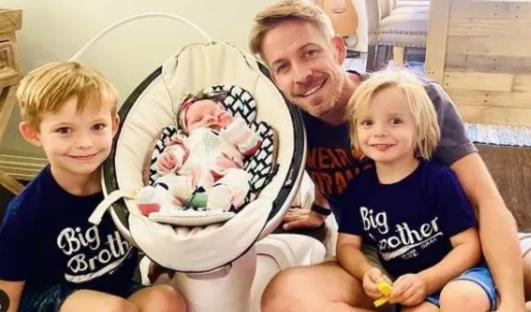 A father with his three children; a newborn baby, a toddler, and a preschooler.