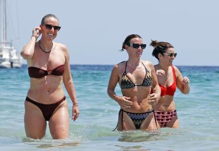 Three women in bikinis in the ocean.