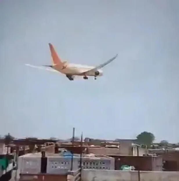 Airplane landing over buildings.