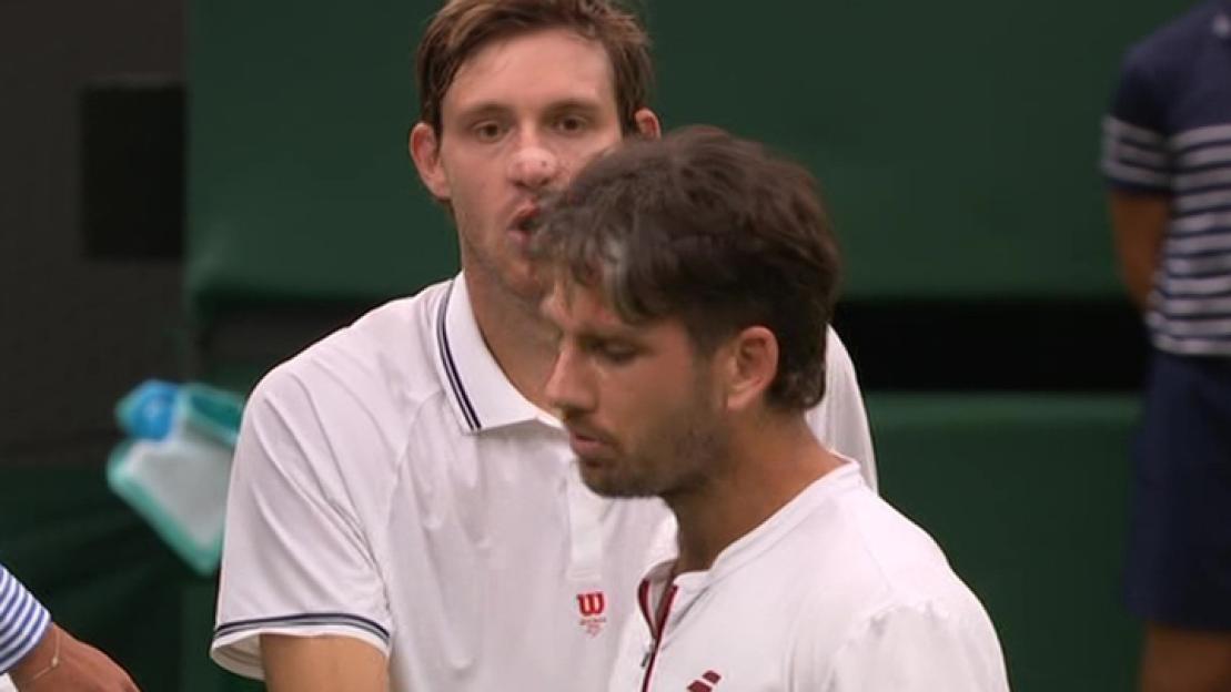 Two tennis players in white shirts.