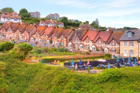 Row of houses on a hillside overlooking a pub patio.