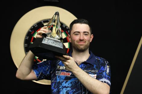 Luke Humphries holding the Premier League Darts trophy.